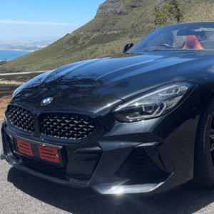 Black BMW Z4 M40i sports car parked with a mountainous backdrop.