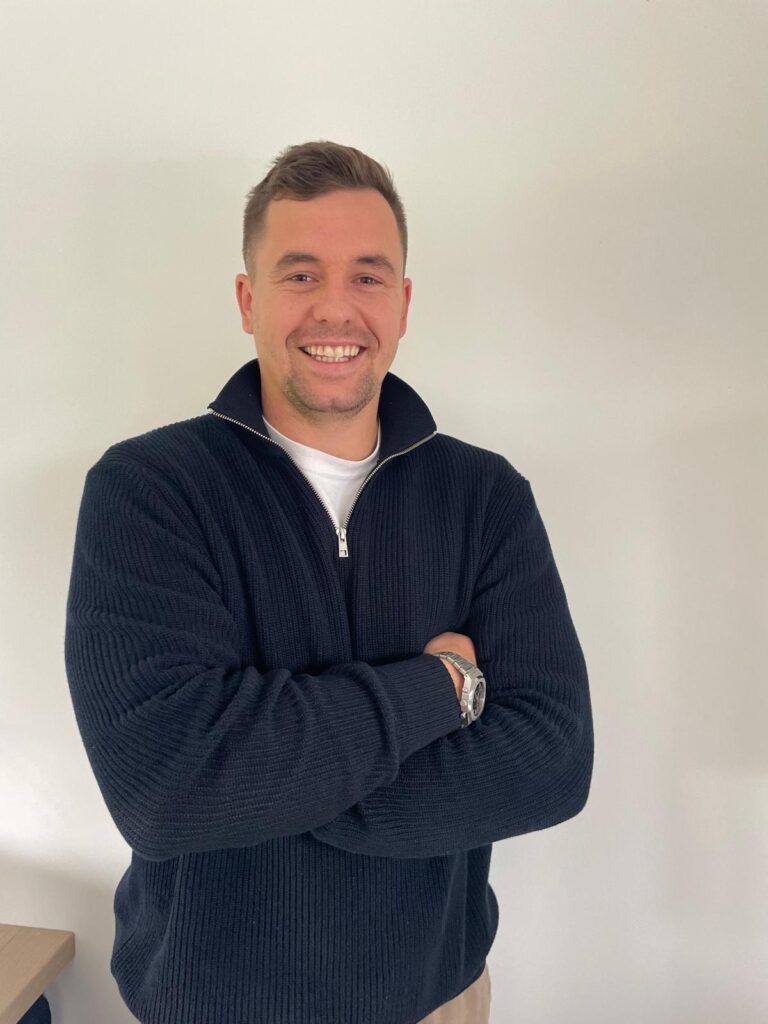 Owner of Luxury Car Rental Cape Town, smiling and standing with arms crossed.